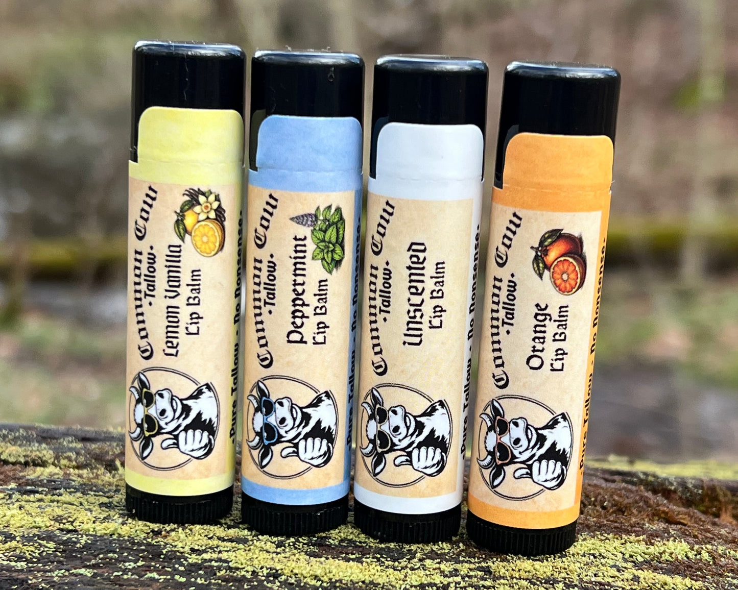 Four lip balm tubes stacked against a tree trunk
