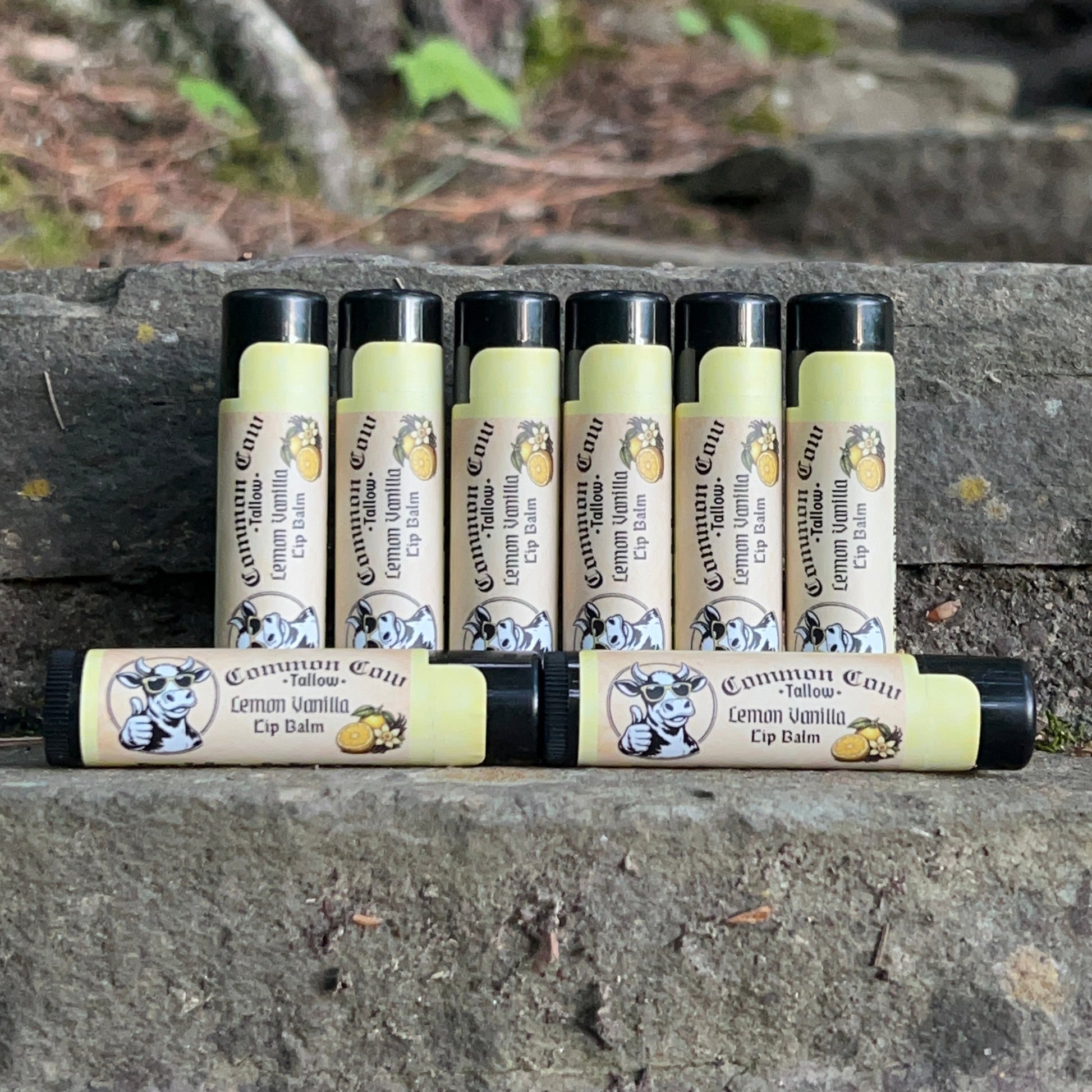 Row of lip balm tubes with visible branding on a stone surface.
